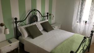 雷卡纳蒂港La dolce vita的一间卧室配有一张绿色和白色条纹的床