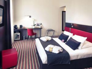 昂古莱姆法国昂古莱姆美居酒店的酒店客房设有一张大床和红色床头板