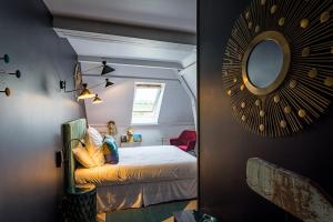 莫索特Hôtel - Restaurant Le Globe的卧室配有一张床,墙上设有镜子