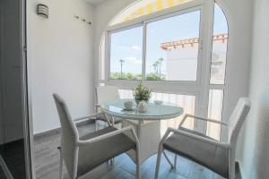 托雷维耶哈Costa Blanca Bungalow Lago jardin frente piscina 4 personas的一间带桌椅和窗户的用餐室