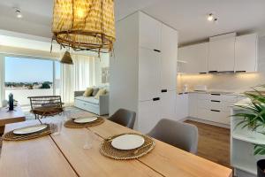 阿尔布费拉Apartamento Boavista - Sea View的厨房以及带木桌和椅子的用餐室。