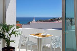 阿尔布费拉Apartamento Boavista - Sea View的海景阳台上的桌椅