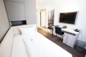 美因河畔法兰克福曼哈顿酒店的一间卧室配有一张床、一张书桌和一台电视。