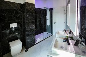 罗马度假豪华套房酒店的一间带水槽、淋浴和卫生间的浴室
