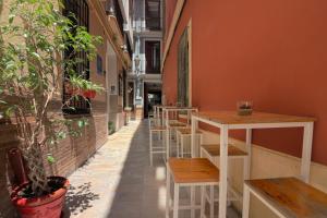 马拉加城市中心感觉旅馆的建筑物边的一排桌子和凳子