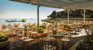 弗尔萨尔Maistra Select Petalon Resort的水边设有桌椅的餐厅