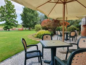 特雷维索阿尔塔别墅住宿加早餐旅馆的一个带桌椅和遮阳伞的庭院