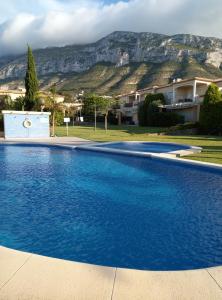 德尼亚El Respiro verde的一个大蓝色游泳池,背景是一座山