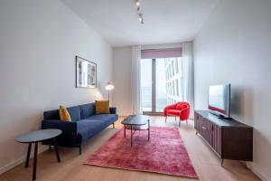 阿姆斯特丹PREMIER SUITES PLUS Amsterdam的客厅配有蓝色的沙发和红色的椅子