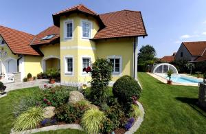 Rohrendorf bei KremsGästehaus Familie Trachsler的庭院里一座带游泳池的黄色房子