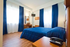 阿西西唐尼尼酒店的酒店客房带蓝色的床和蓝色窗帘