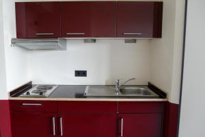 汉堡Base Apartments的一间带红色橱柜和水槽的厨房