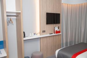 卡迪夫卡迪夫湾智选假日酒店的酒店客房设有一张床和墙上的电视