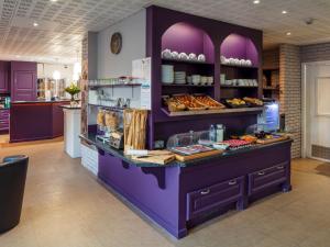 瓦朗斯堡Noemys Valence Nord - hotel restaurant的面包店,带紫色柜台,上面有食物