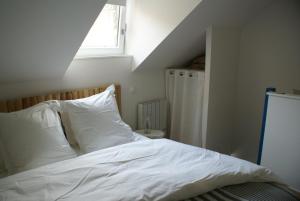 里尔拉考尔苏博思品酒店的一间卧室配有一张带白色床单的床和一扇窗户。