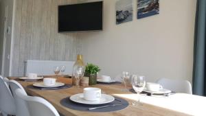 勒特朗舍芒Cassandria Bad - luxe Glamping的餐桌、椅子和墙上的电视