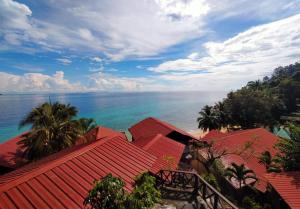 刁曼岛帕纳巴度假酒店的拥有红色屋顶的度假村享有海洋美景