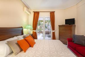 帕利尼Villa Maya的一间卧室配有一张床和一张红色的沙发