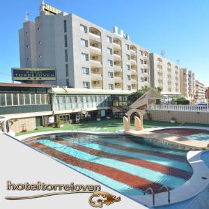 托雷维耶哈新塔酒店的一座大建筑前的游泳池