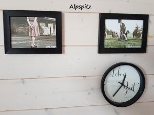 加尔米施-帕滕基兴Apartment Kramer und Alpspitz的墙上有三幅照片和一个时钟