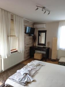 内塞伯尔Guest House Juja的卧室配有一张床、一张书桌和窗户。