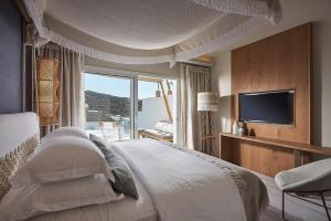 普拉迪斯亚罗斯帕雷蒂亚姆酒店的一间卧室配有一张大床和电视