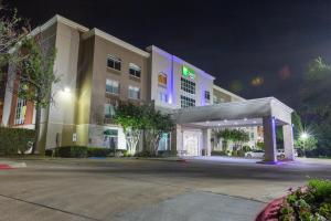 阿林顿Holiday Inn Express & Suites Arlington North – Stadium Area, an IHG Hotel的一家晚上设有加油站的酒店大楼