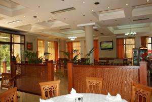 爱尔巴桑Hotel Colombo Elbasan的一间带桌椅和电视的用餐室