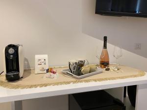 阿尔盖罗Le Calette 105的一张带咖啡壶的桌子和一瓶葡萄酒