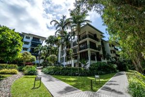 棕榈湾棕榈湾保护区酒店的一座棕榈树建筑和前面的走道