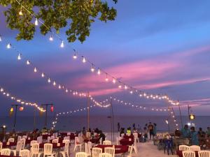 沙美岛沙美岛心萨姆特酒店的一群人坐在海滩上椅子上,灯光照亮
