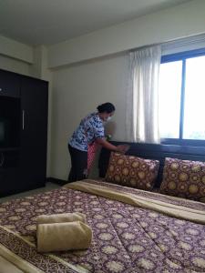 曼谷欧洲广场酒店的一位妇女站在带两张床的房间