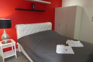 班佩VIP度假村热带别墅的红色卧室,配有带毛巾的床