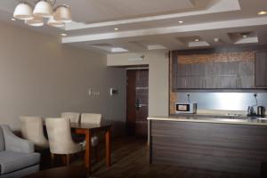 艾卜哈Dar Telal Hotel suites的客厅设有厨房、桌子和椅子