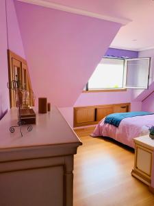 塞代拉Ático en primera línea de playa的紫色卧室设有一张床和一个窗户