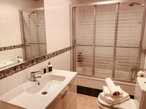 塞代拉Ático en primera línea de playa的白色的浴室设有水槽和淋浴。