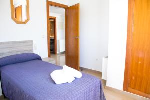 卡尔佩Sotavento Atico Calpe的一间卧室配有一张紫色床和毛巾