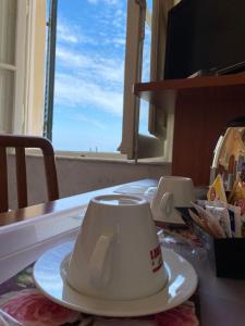 马里纳迪马萨意大利酒店的坐在窗前桌子上的咖啡杯