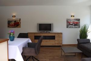 拉古多Ferienwohnung mit Garage, Fahrradraum und sehr großer sonnenverwöhnten Terrasse的客厅配有桌子、电视和沙发