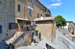 LubrianoLe Calanque La Terrazza su Civita的阳台上的砖砌建筑,种植了盆栽植物