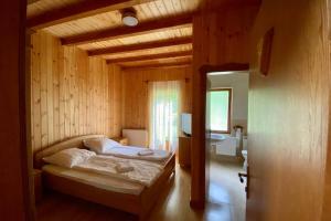 IzvoarePlatán Vendégház的木制客房内的一间卧室,配有一张床