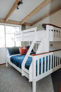 坎贝尔港PC度假屋的配有白色双层床的客房内的双层床