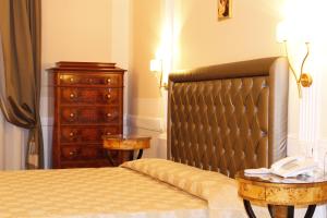 罗马特雷维精品酒店的一间卧室配有一张床和一个带电话的梳妆台。