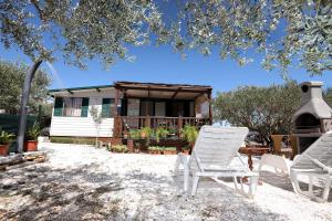 特罗吉尔Olive garden Trogir - mobil home的两把草坪椅和一个带凉亭的房子