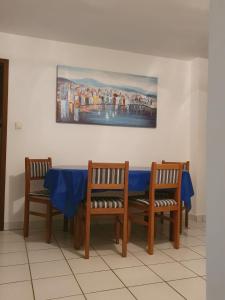 库斯提奇Apartman Rosa 2的一张桌子,配有两把椅子和一张蓝色的桌布