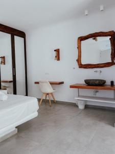 米克诺斯城Eternal Suites的一间卧室配有床、水槽和镜子