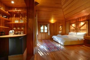 契拉勒Cirali Armira Bungalow的木制客房内的一间卧室,配有一张床