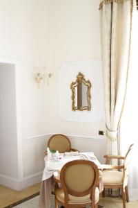罗马平西安纳别墅酒店的一间带桌椅和镜子的用餐室