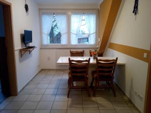 迪尔门Ferienhof & Café Schnieder的一间带桌子和两把椅子的用餐室以及窗户。