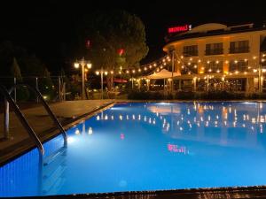 杰尔宾特莫塔里生活酒店的一座游泳池,在晚上在建筑物前